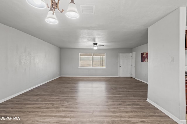 unfurnished living room with ceiling fan with notable chandelier and hardwood / wood-style flooring