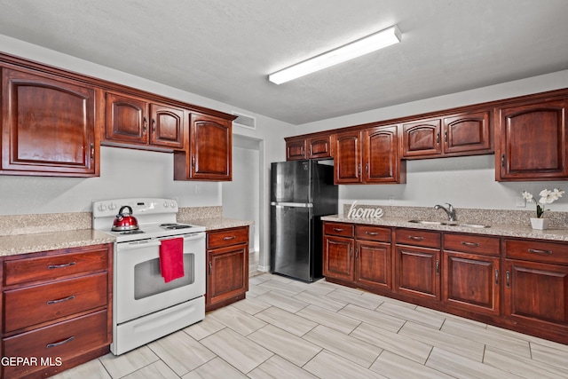 kitchen with black fridge, light stone countertops, electric range, and sink