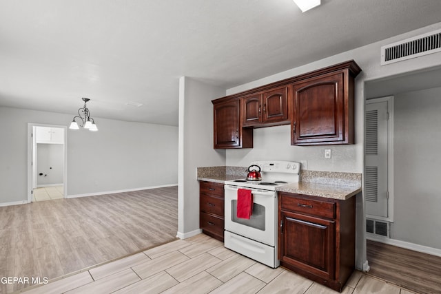 kitchen featuring light wood-type flooring, electric range, a chandelier, and pendant lighting