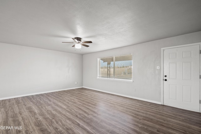 unfurnished room with ceiling fan and dark wood-type flooring