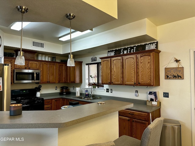 kitchen with sink, stainless steel appliances, hanging light fixtures, and kitchen peninsula