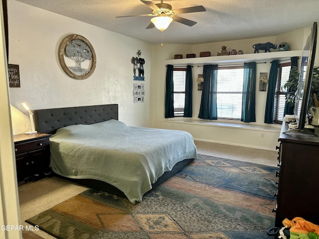 bedroom featuring ceiling fan, carpet floors, and a textured ceiling