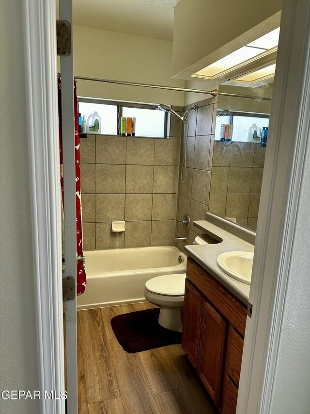 full bathroom with wood-type flooring, toilet, vanity, and shower / bath combo