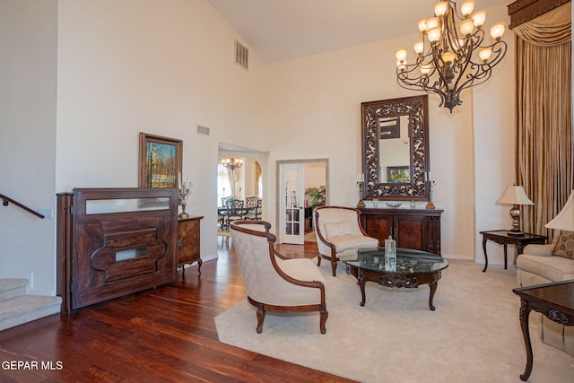 living area with french doors, an inviting chandelier, dark hardwood / wood-style floors, and high vaulted ceiling