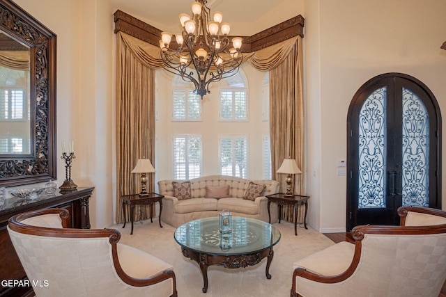 sitting room with french doors and a notable chandelier