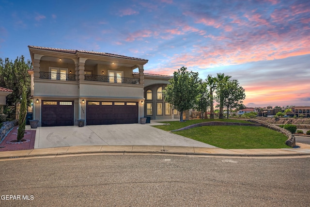 mediterranean / spanish-style home featuring a yard, a balcony, and a garage