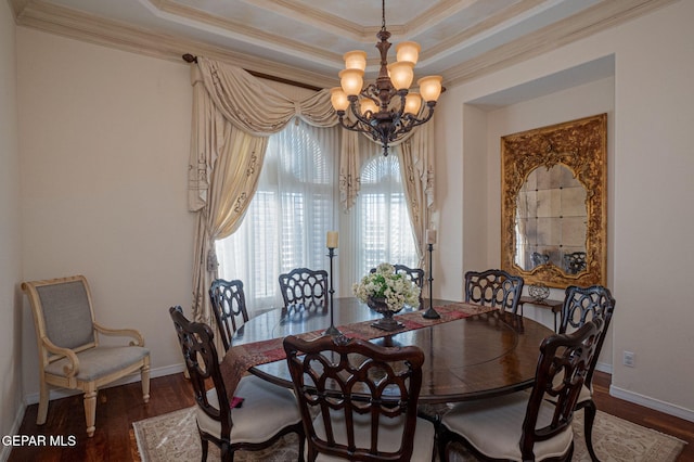 dining room featuring a tray ceiling, an inviting chandelier, dark wood-type flooring, and crown molding