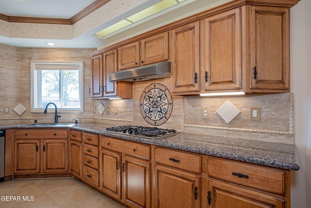 kitchen featuring sink, stainless steel appliances, crown molding, a tray ceiling, and light tile patterned floors