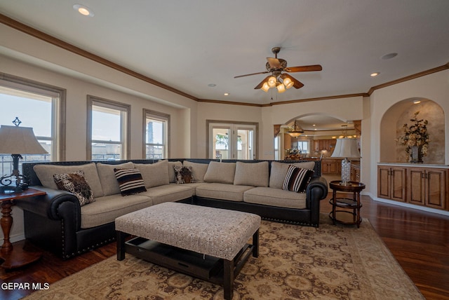 living room featuring dark hardwood / wood-style floors, ceiling fan, and crown molding