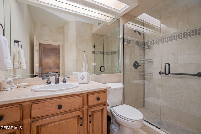 bathroom featuring vanity, a shower with shower door, and toilet