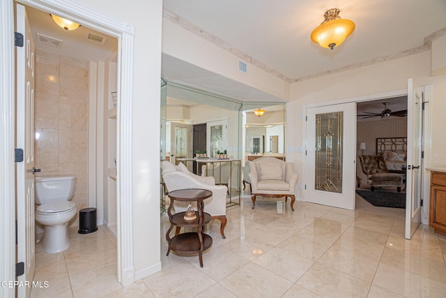 bathroom featuring french doors, toilet, ceiling fan, and tile walls