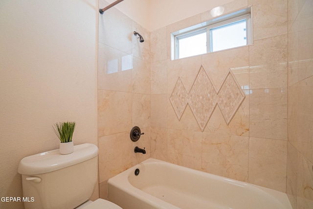 bathroom with toilet and tiled shower / bath