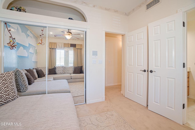 carpeted living room featuring crown molding and ceiling fan