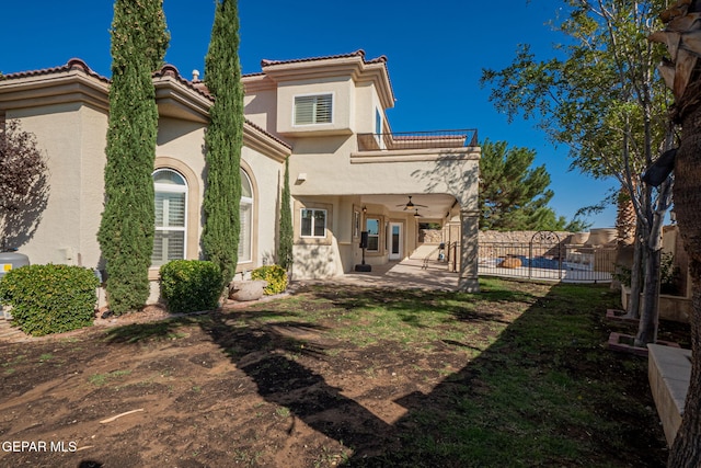 back of property with ceiling fan and a patio area