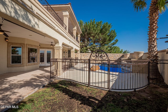 view of pool with french doors, a patio, and ceiling fan