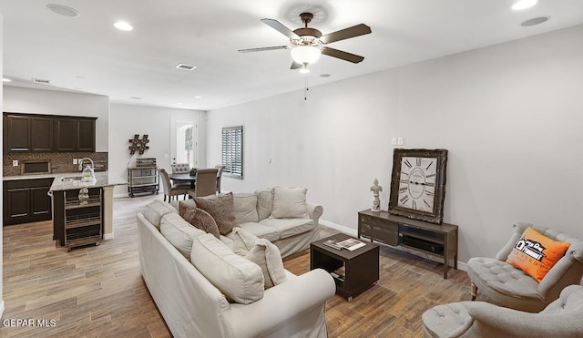 living room with ceiling fan and beverage cooler