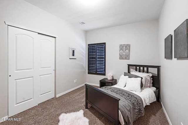 bedroom with a closet and dark colored carpet