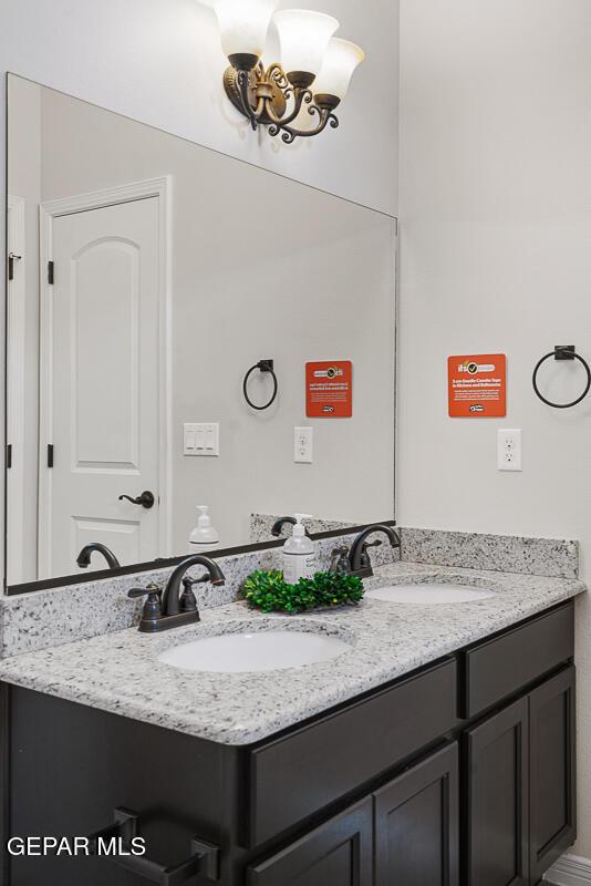 bathroom with a notable chandelier and vanity