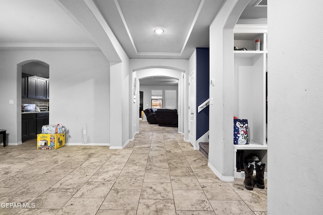 hall featuring a raised ceiling