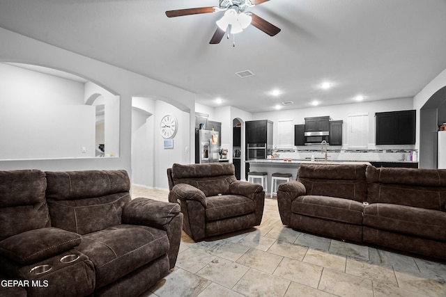 living room featuring ceiling fan and sink