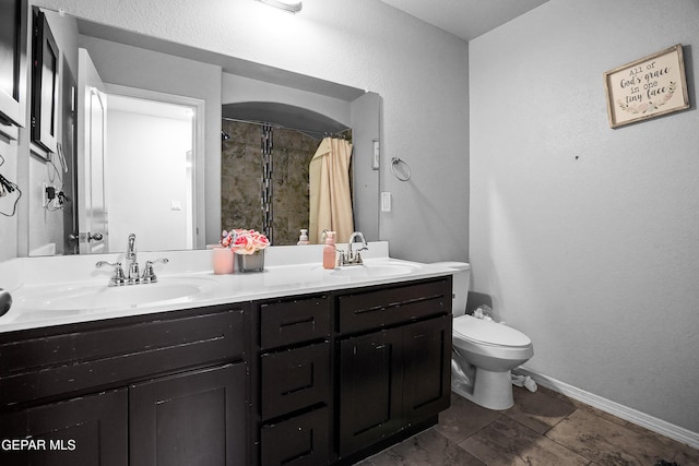 bathroom featuring vanity, toilet, and curtained shower