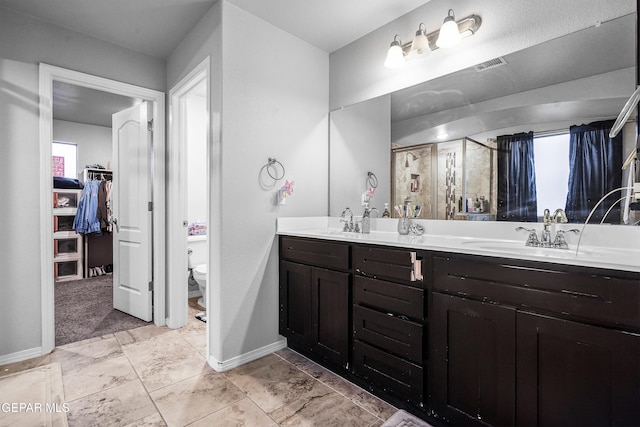 bathroom featuring toilet, vanity, and walk in shower