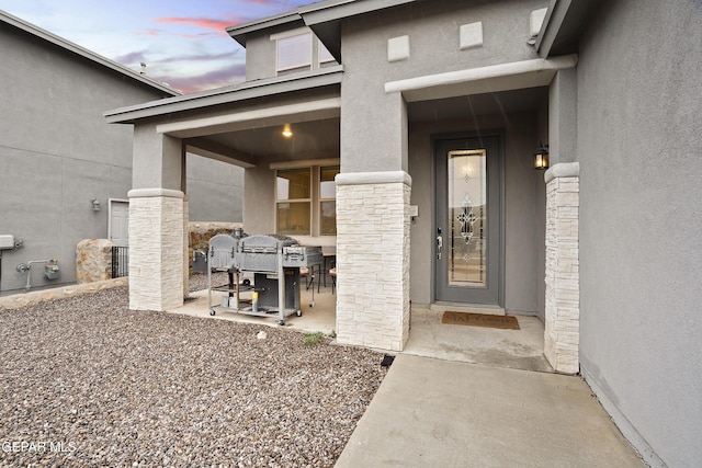 exterior entry at dusk with a patio