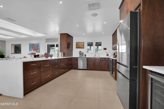 kitchen featuring plenty of natural light, sink, stainless steel appliances, and wine cooler