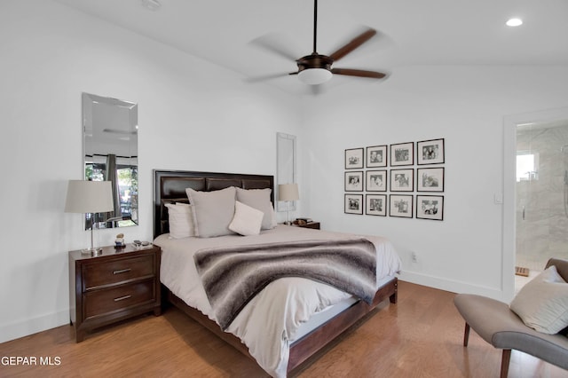 bedroom with connected bathroom, ceiling fan, lofted ceiling, and light wood-type flooring