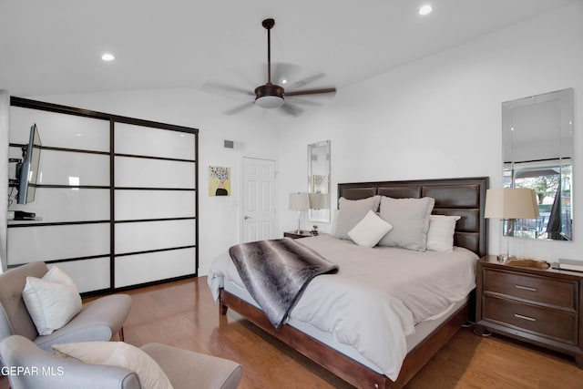 bedroom featuring ceiling fan, light wood-type flooring, and lofted ceiling