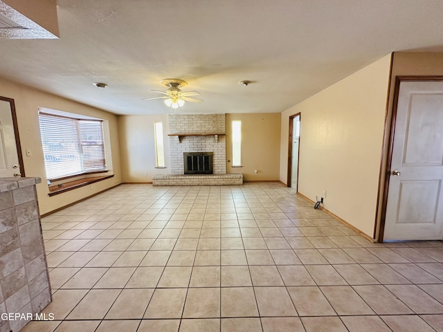 unfurnished living room with ceiling fan, light tile patterned floors, and a fireplace