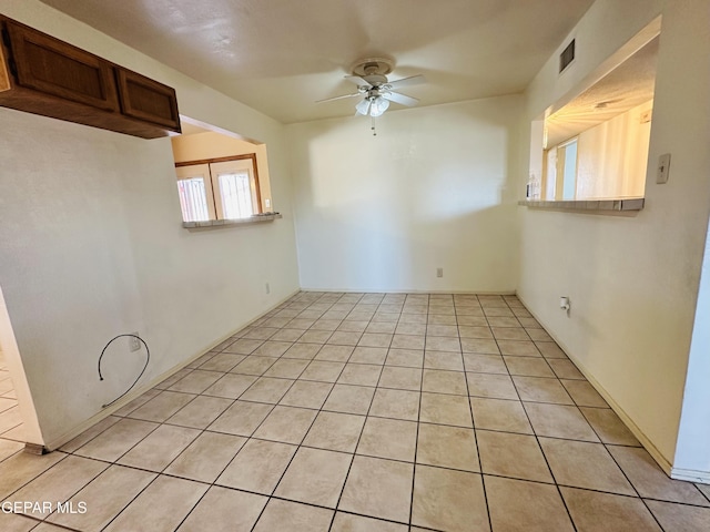 spare room featuring ceiling fan and light tile patterned flooring