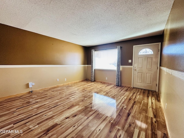 entryway with light hardwood / wood-style flooring and a textured ceiling