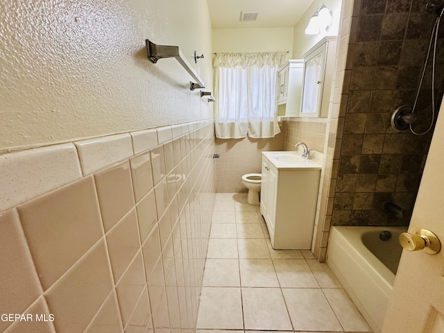 full bathroom featuring tile patterned floors, shower / bathtub combination, vanity, tile walls, and toilet