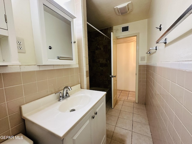 bathroom featuring tile patterned flooring, vanity, and tile walls