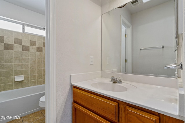 full bathroom featuring toilet, vanity, and tiled shower / bath