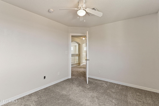 carpeted spare room featuring ceiling fan and a textured ceiling