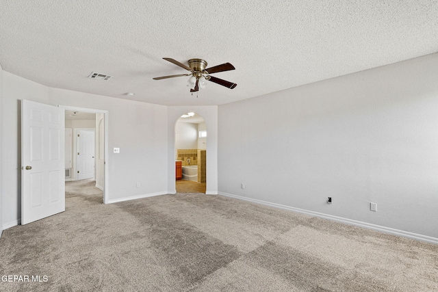 spare room with light carpet, ceiling fan, and a textured ceiling