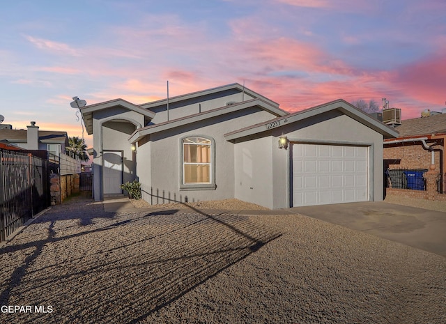 view of front of house featuring a garage and central AC