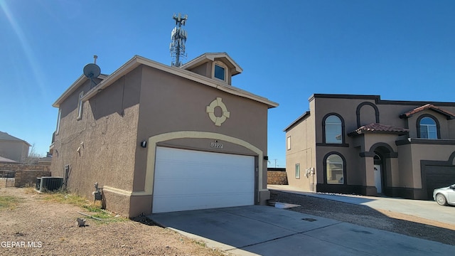 view of front of property featuring a garage and central air condition unit