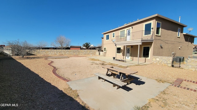 rear view of property with a balcony, a patio, and central AC unit