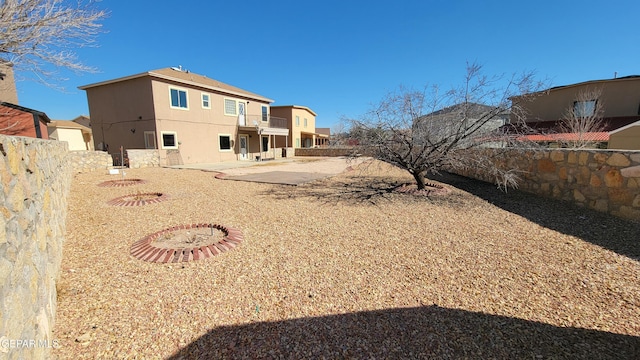 rear view of property with a patio and a balcony