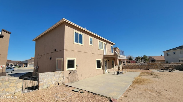 back of house featuring a patio area and a balcony