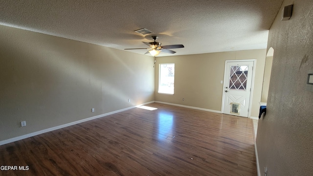 unfurnished room featuring ceiling fan, wood-type flooring, and a textured ceiling