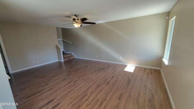 unfurnished living room featuring dark hardwood / wood-style floors and ceiling fan