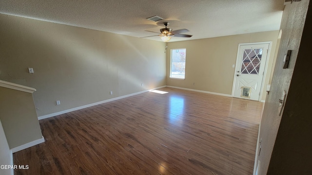 interior space with a textured ceiling, dark hardwood / wood-style floors, and ceiling fan