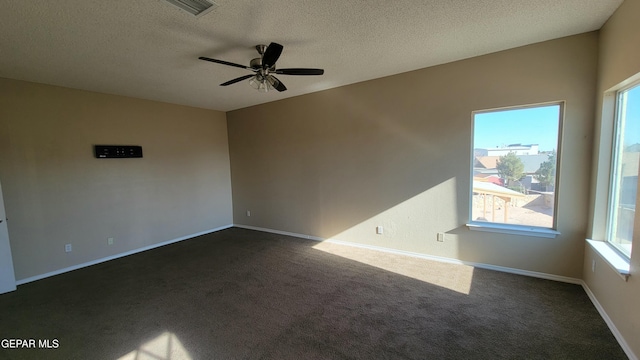 empty room with ceiling fan, dark carpet, and a textured ceiling