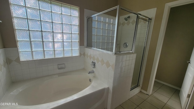 bathroom with separate shower and tub and tile patterned flooring