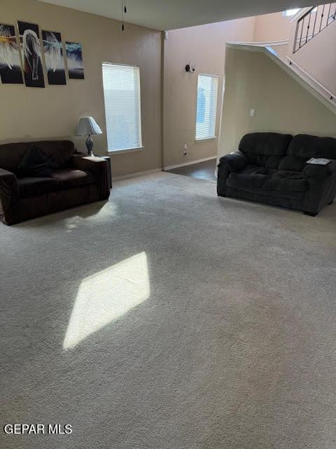 carpeted living room with ceiling fan