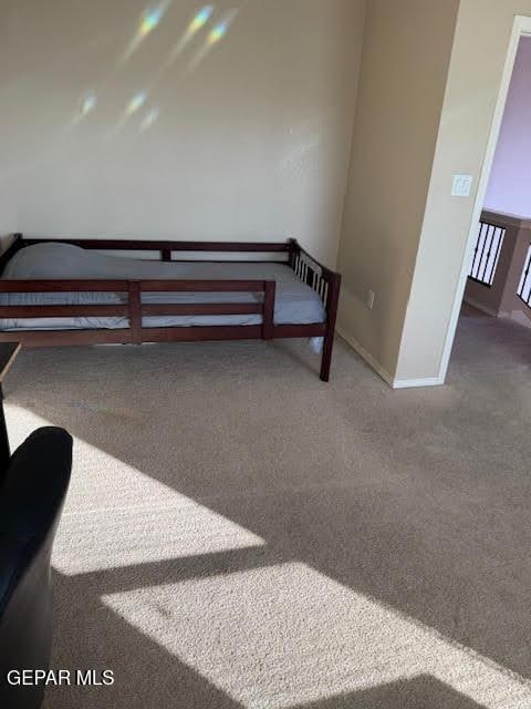 bedroom with baseboards and dark colored carpet